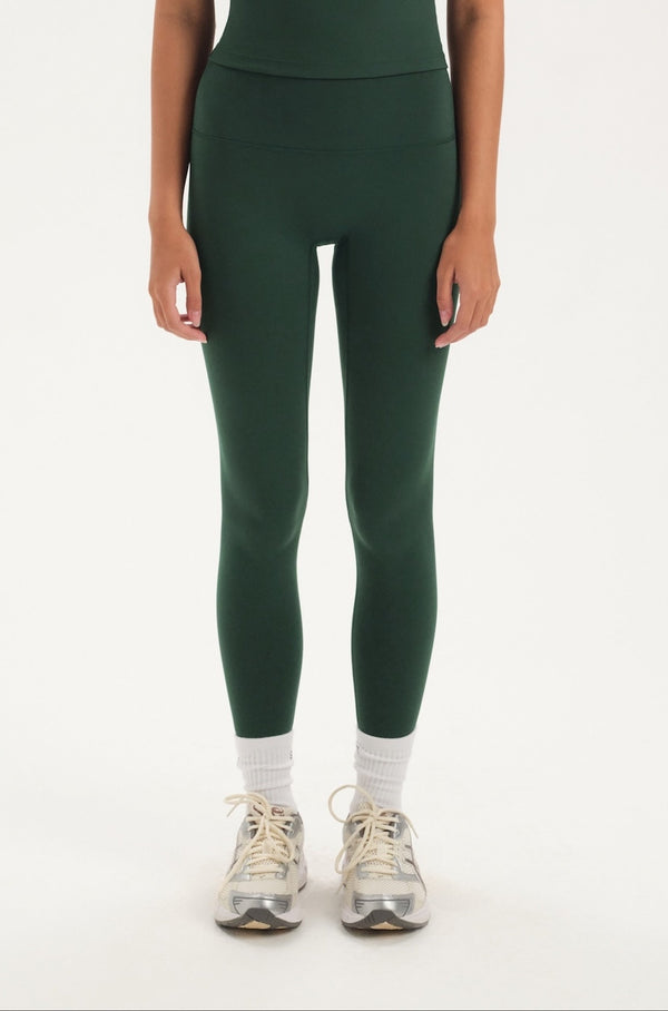 Woman wearing green leggings on a white background 