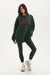 Woman wearing a green oversized sweatshirt and leggings with 'SET' text on a white background