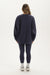 Person wearing a navy oversized sweatshirt and leggings on a white background