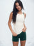Woman wearing a white tank top and green shorts on a light gray background