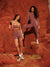 Two women in matching athletic wear standing on a rocky surface.