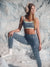 Woman in athletic wear posing against a snowy background
