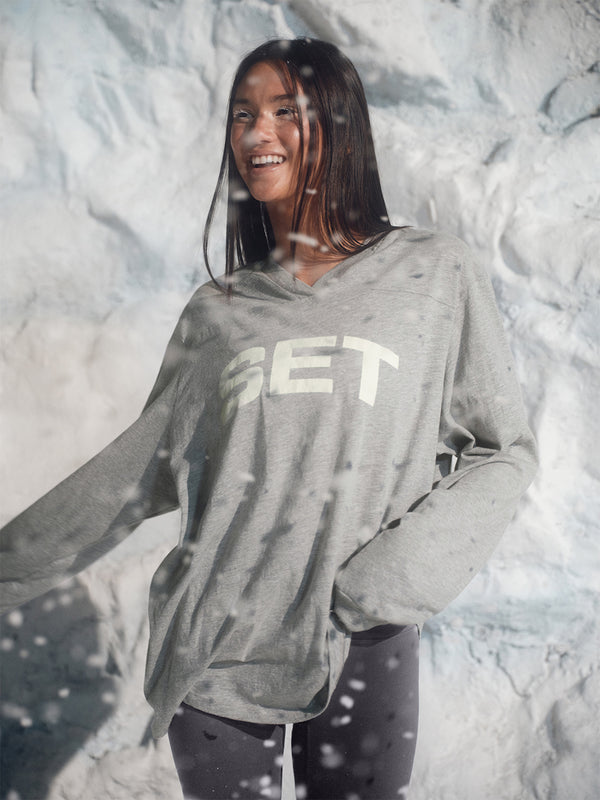 Person wearing a gray hoodie with 'GET' printed on it, standing against a snowy background.