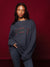 Person wearing a navy sweatshirt with plaid text on a red background <model-info>Sydney wears a size L and is 5’9, 24½” waist, 32B bust.</model-info>
