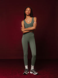 Woman wearing a green athletic outfit on a red background