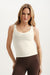 Woman wearing a white tank top and brown leggings on a light background <model-info>Maranda wears a size XS and is 5’10”, 24½” waist, 33” bust.</model-info>