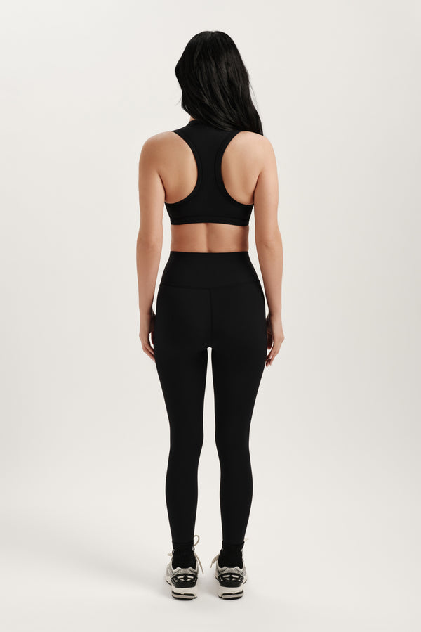 Person wearing a black athletic outfit on a white background