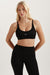 Woman wearing a black sports bra and leggings with a visible brand logo on a light background <model-info>Kenzie wears a size S and is 5’6, 25” waist, 33” bust.</model-info>