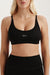 Black sports bra with 'SET' logo worn by a person on a white background