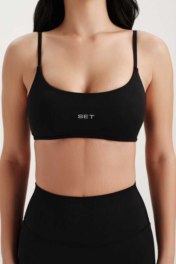Black sports bra with 'SET' branding on a plain background