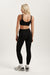 Person wearing a black sports bra and leggings set on a white background