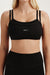 Black sports bra with 'SET' branding worn by a person on a light background