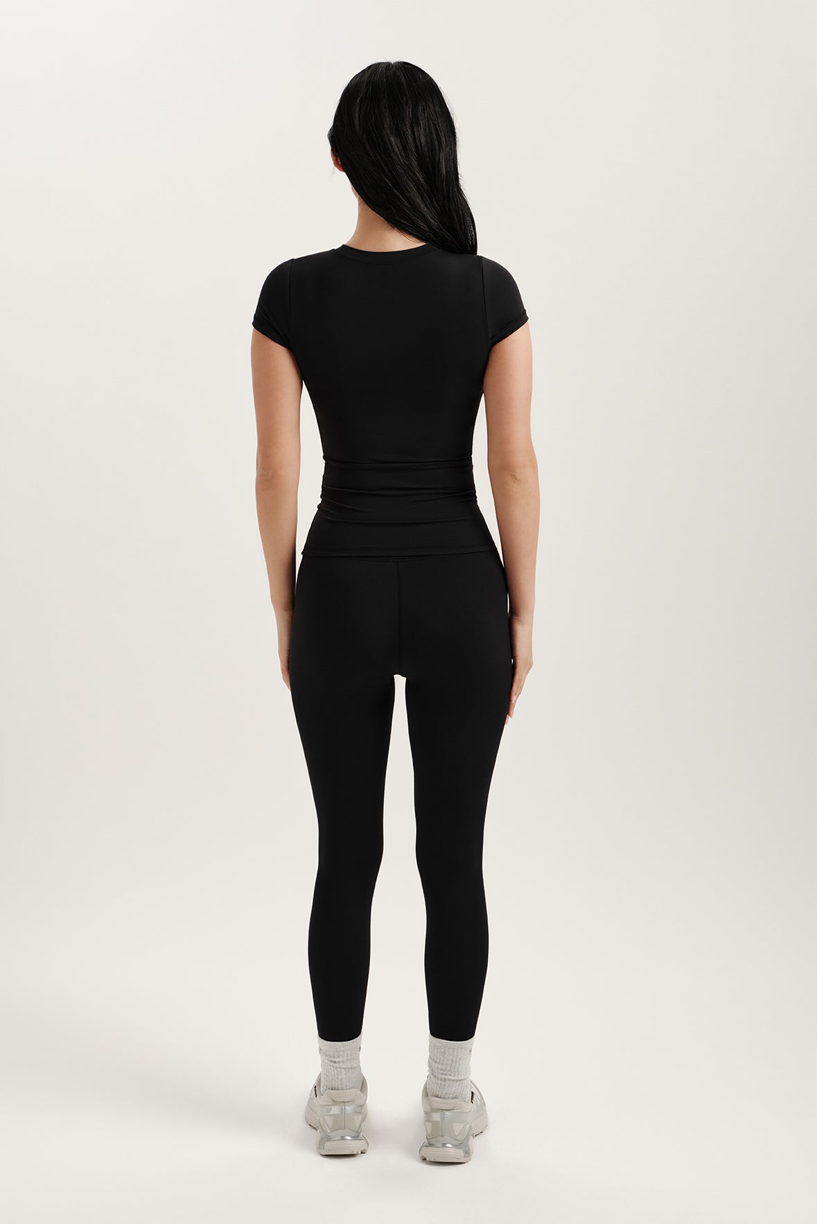 Person wearing a black outfit on a white background