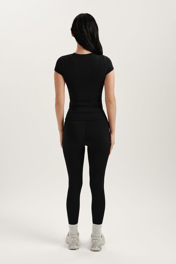 Person wearing a black outfit on a white background