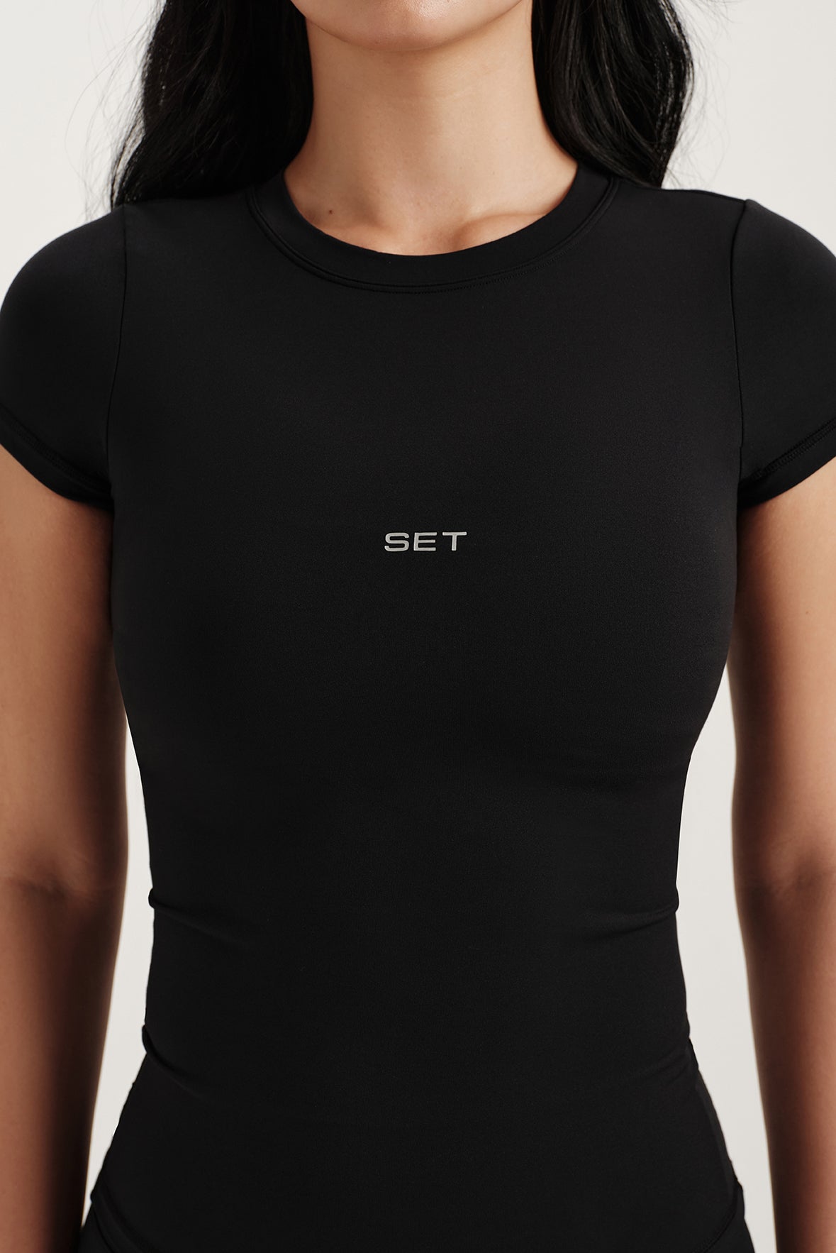 Black t-shirt with 'SET' logo worn by a person on a white background