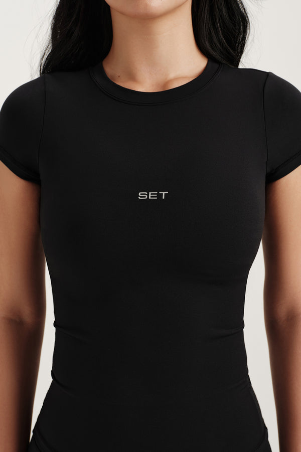 Black t-shirt with 'SET' logo worn by a person on a white background