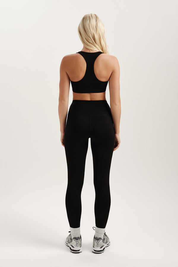 Person wearing a black athletic outfit on a white background