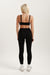 Person wearing a black sports bra and leggings set on a white background