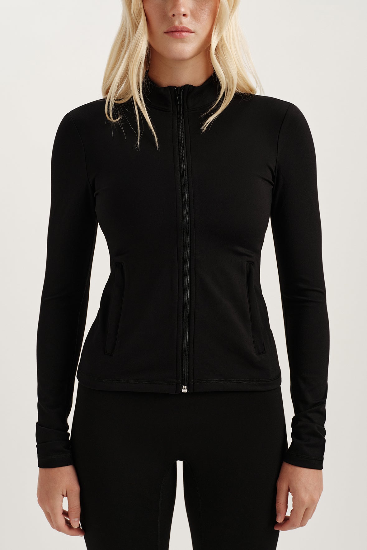 Black zip-up jacket worn by a person on a white background