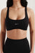 Black sports bra with 'SET' logo worn by a person on a plain background
