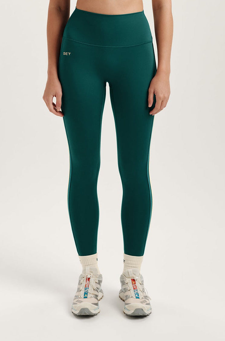 Person wearing teal leggings with a white background 