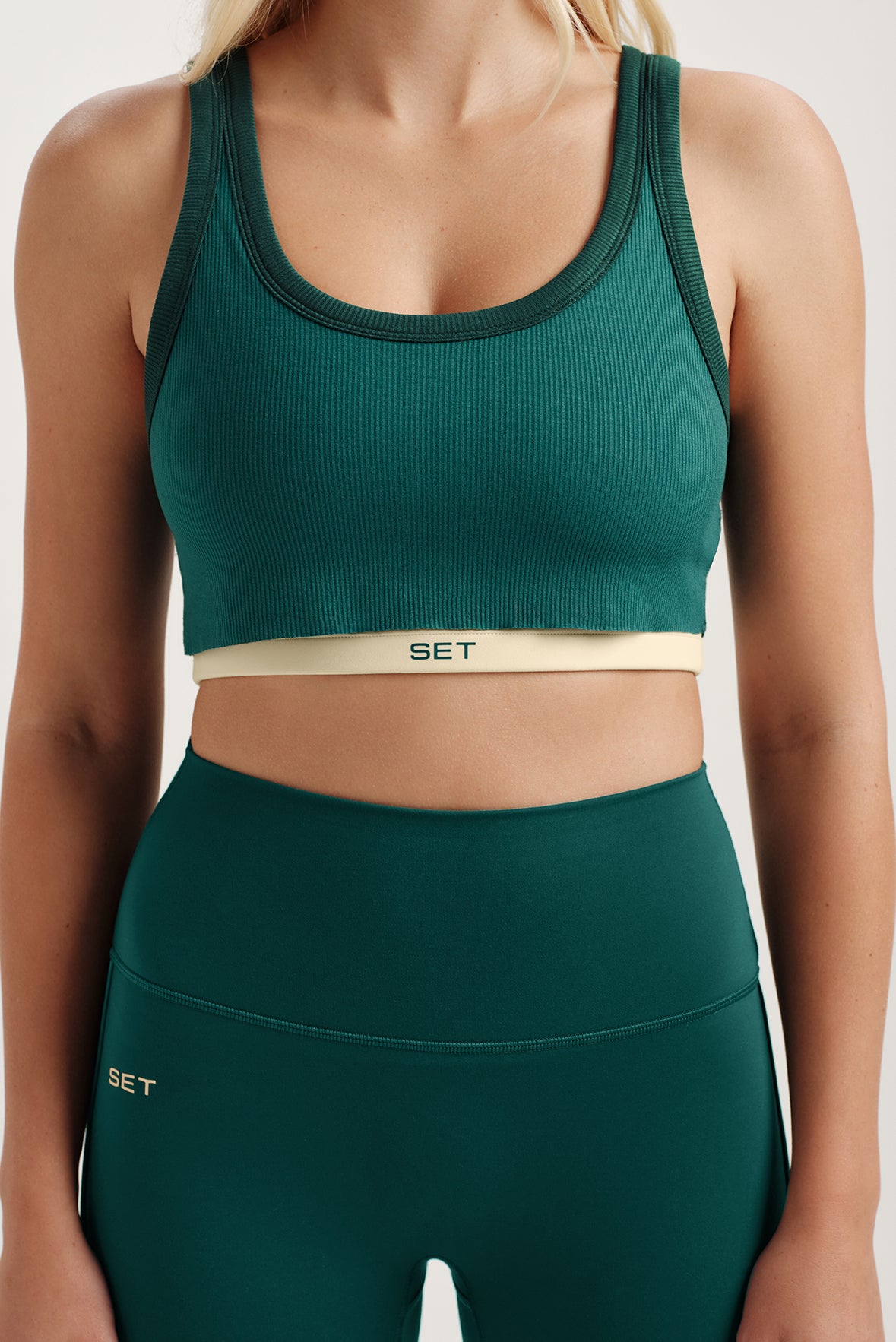 Green sports bra and leggings with 'SET' branding on a neutral background