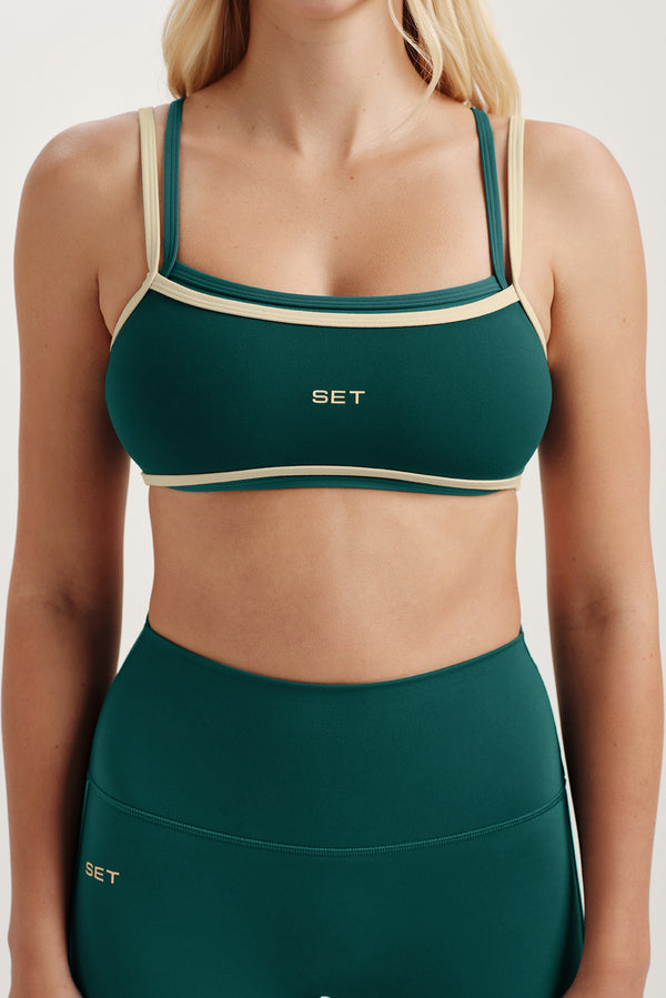 Green sports bra and leggings with 'SET' branding on a neutral background