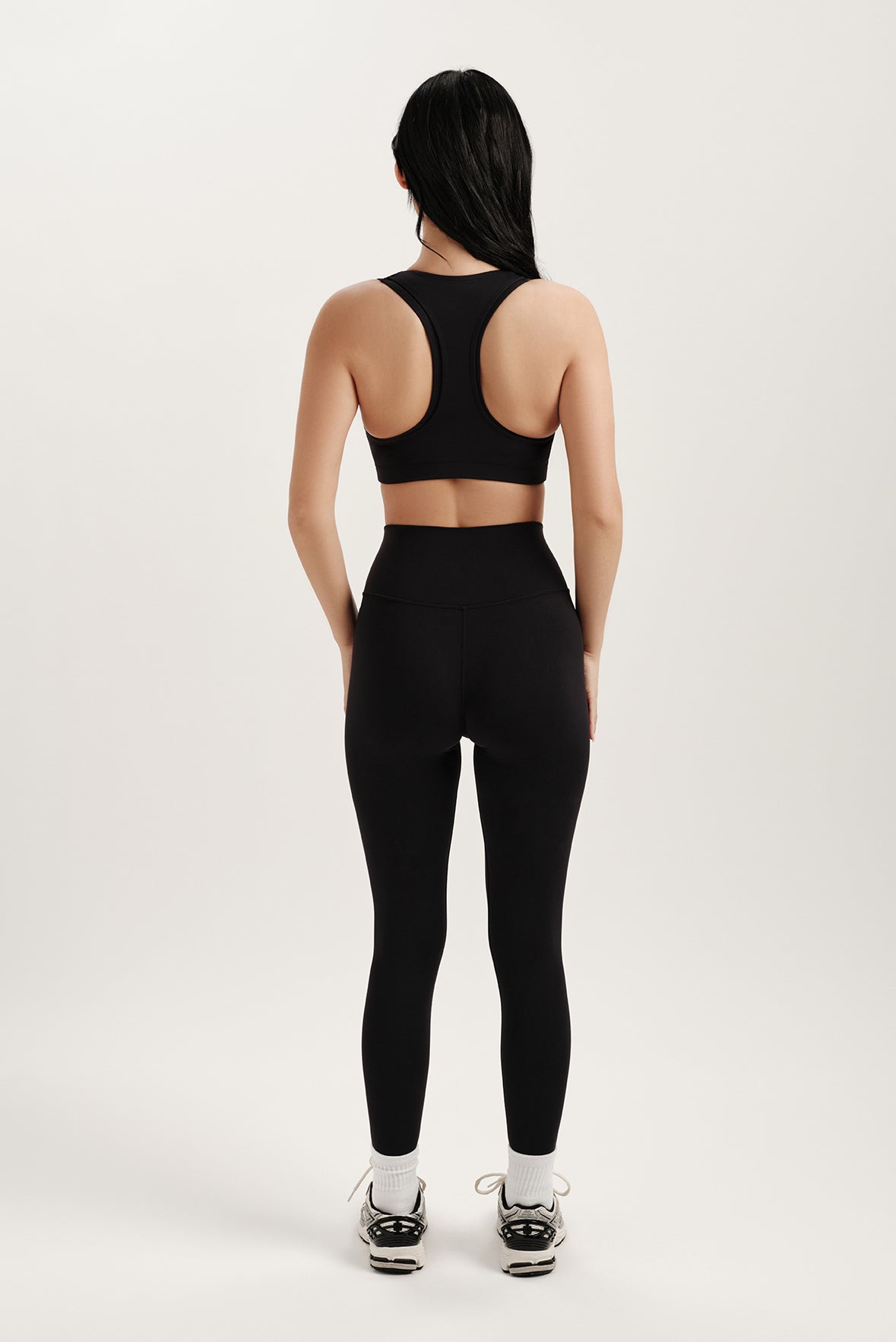 Person wearing a black athletic outfit on a white background