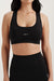 Person wearing a black sports bra with 'SET' logo on a white background