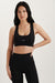 Woman wearing a black sports bra and leggings with 'SET' branding on a light background <model-info>Jasmine wears a size S and is 5’8, 25” waist, 32C bust.</model-info> 