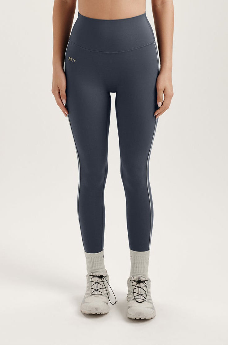 Woman wearing gray leggings on a white background 