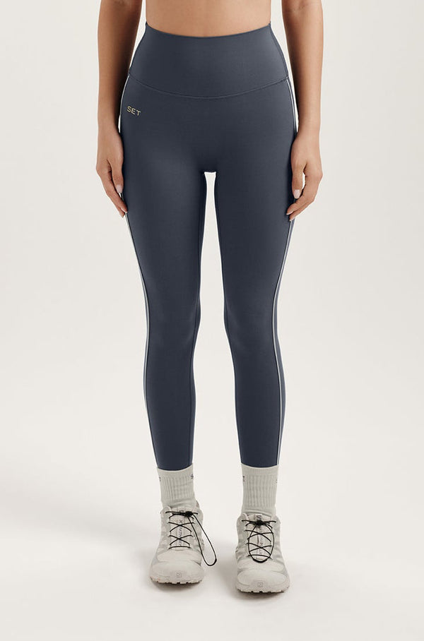 Woman wearing gray leggings on a white background 