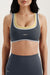 Woman wearing a gray sports bra and leggings with 'SET' branding on a light background