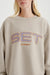 Beige sweatshirt with 'SET SUMMIT' text worn by a person