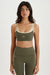 Woman wearing a green sports bra and leggings set on a white background <model-info>Meeya wears a size XS and is 5’7, 23” waist, 32B bust.</model-info> 