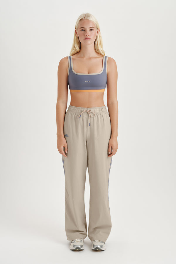 Woman wearing a sports bra and jogger pants on a white background