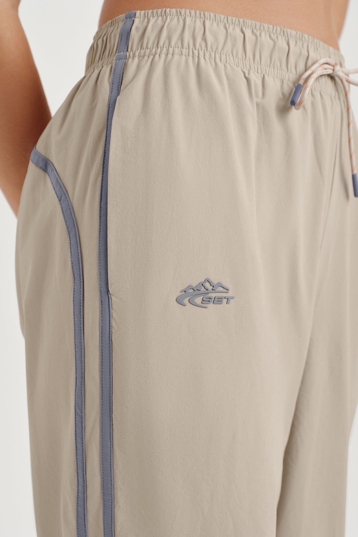 Beige pants with a logo on a plain background