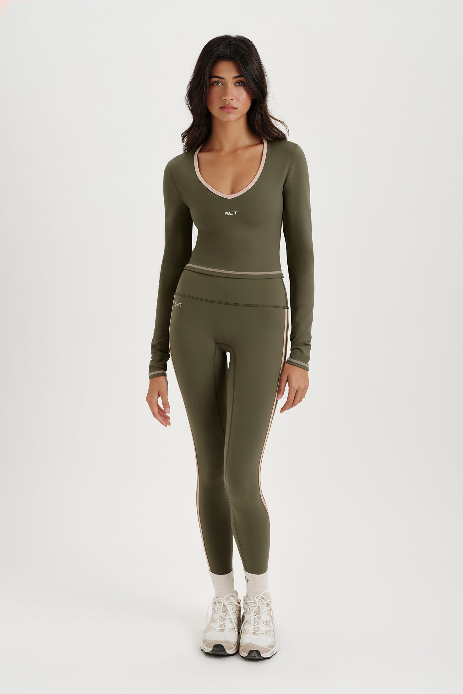 Woman wearing a green athletic outfit on a white background