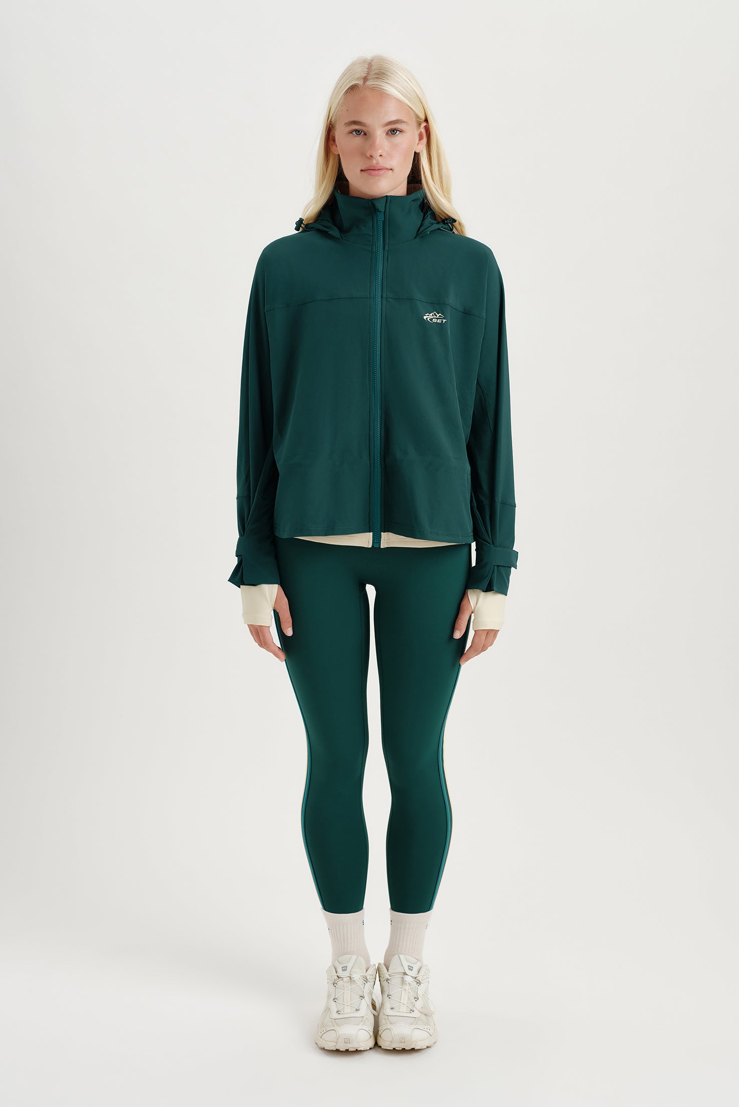 Woman wearing a green jacket and leggings on a white background <model-info>Kathryn wears a size S and is 5’8½ , 24” waist, 33B bust.</model-info> 