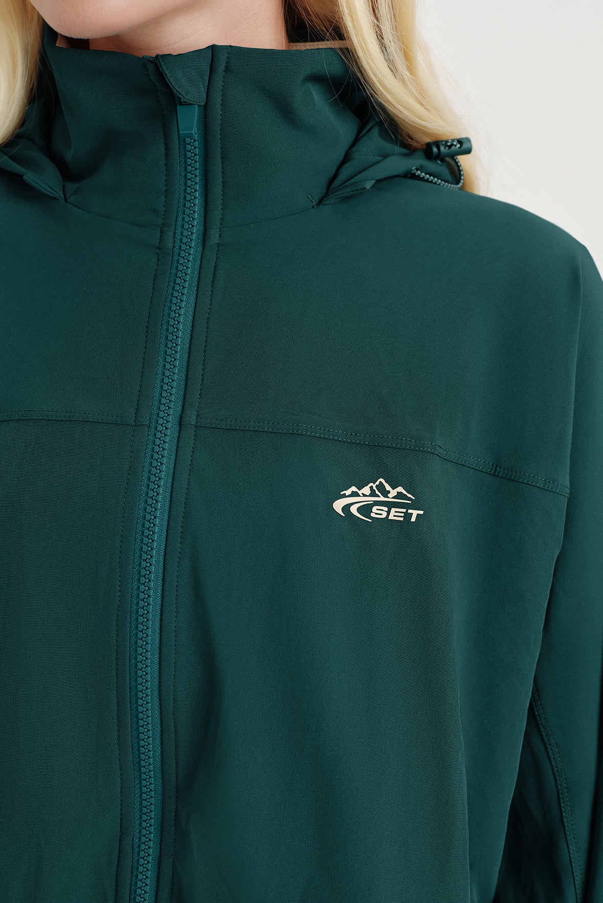 Green jacket with a brand logo on a light background