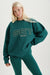Person wearing a teal sweatshirt with 'SET Summit' text on a white background <model-info>Kathryn wears a size S and is 5’8½ , 24” waist, 33B bust.</model-info> 
