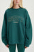 Person wearing a green sweatshirt with 'SET SUMMIT' text on a white background