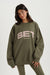 Woman wearing an olive green sweatshirt with 'SET' logo on a white background