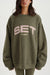 Person wearing a green sweatshirt with 'SET SUMMIT' text on a white background