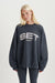 Person standing wearing a grey sweatshirt with 'SET' logo  <model-info>Kathryn wears a size S and is 5’8½ , 24” waist, 33B bust.</model-info> 