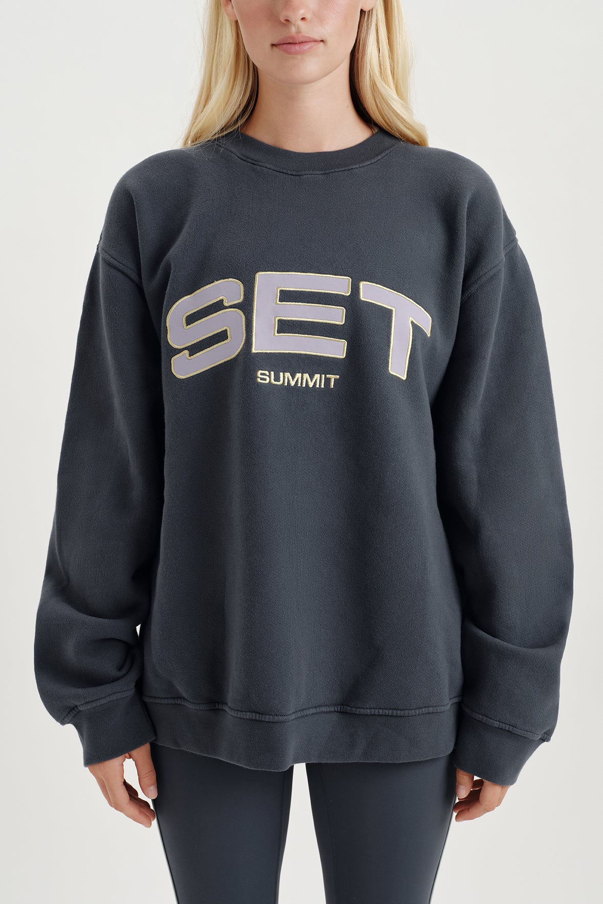 Person wearing a dark gray sweatshirt with 'SET SUMMIT' text on a light gray background