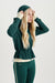 Woman wearing a green tracksuit with a hood on a white background