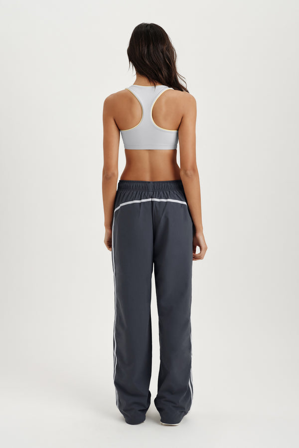 Person standing in gray track pants with light gray sports bra 