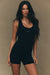 Woman wearing a black jumpsuit and shorts with 'SET' branding on a beige background <model-info>Jelene wears a size XS and is 5’7”, 23” waist, 32AB bust.</model-info>