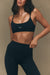 Woman wearing a black sports bra and leggings with 'SET' branding on a beige background
